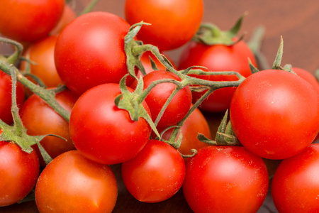 The bunch of tomatoes on the kitchen table ready for preparing the salatの写真素材