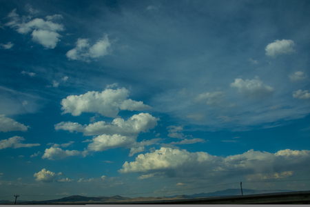 Beautiful view to the blue sky with clouds and some mountain peaks in the distanceの写真素材