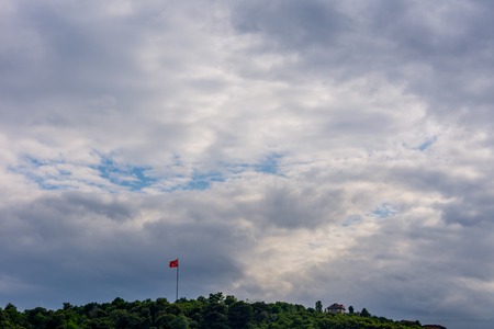 The turkish flag flagging above the trees in the park in Istanbulの写真素材