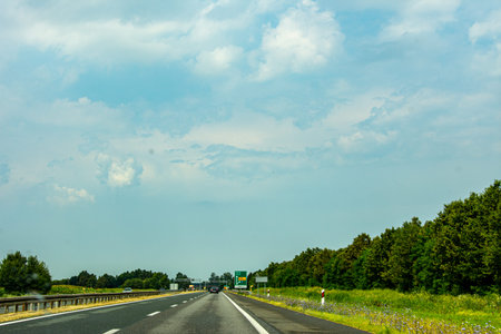 Two lane highway after the rain through the beautiful natural landscape that is leading to the...