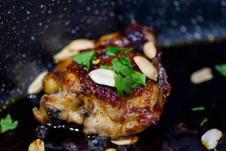 Thai chicken decorated with fresh parsley and peanuts. Closeup of homemade tasty food in ceramic casseroleの写真素材