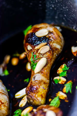 Thai chicken decorated with fresh parsley and peanuts. Closeup of homemade tasty food in ceramic casseroleの写真素材