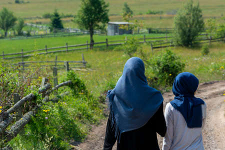 Two muslim girls walking on the rural mountain roadの写真素材
