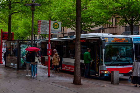 Bus station in Gerhart Hauptmann Platz Hamburg. Bus stopped and people going in and out. Rainy day. HAMBURG, GERMANY, 08. MAY 2014のeditorial素材
