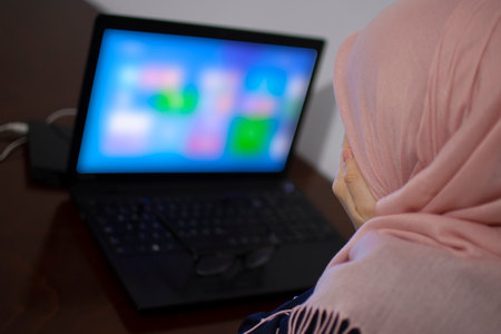 Tired muslim student after online classes holding hands over the face in front of the laptop. Female worker at home. Corona or covid 19 pandemic. New lifestyleの写真素材