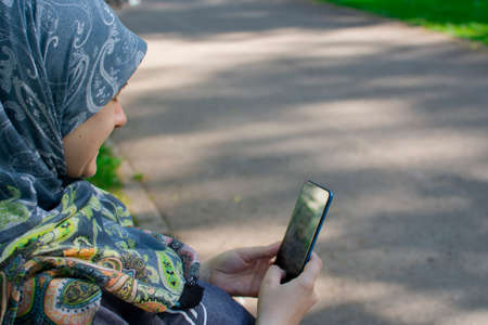 Muslim pregnant woman taking selfie in the park. Memories of the pregnancy lifestyleの写真素材