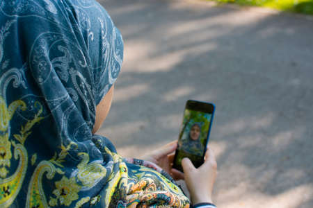 Muslim pregnant woman taking selfie in the park. Memories of the pregnancy lifestyleの写真素材