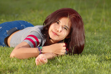 teen girl on the green grass の写真素材
