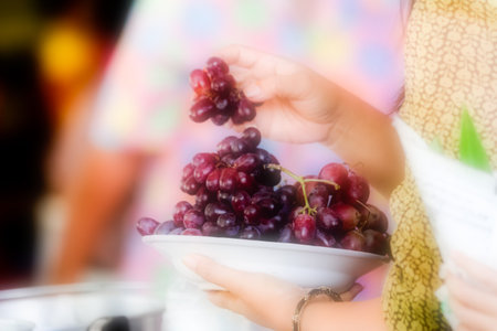 Soft focus Grapes on a plate on the hands of women.