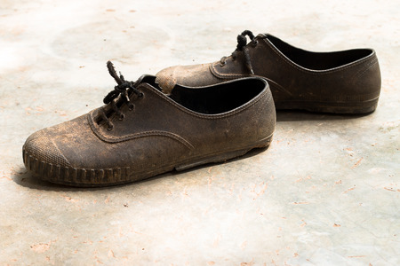 Old and dirty rrubber footwear on the cement floor.の写真素材