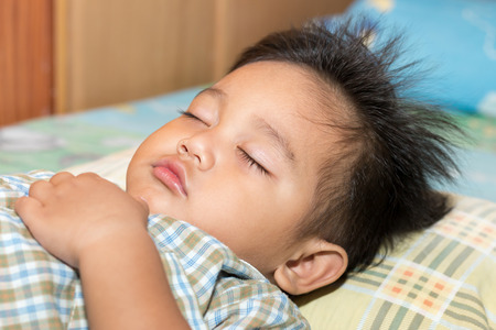 The boy was sleeping with happiness.の写真素材