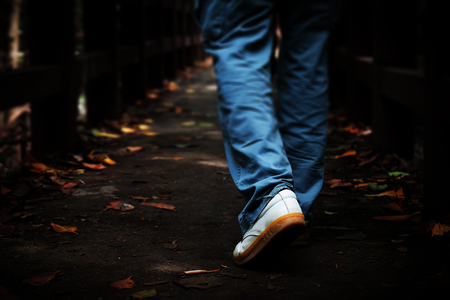 Blurred man walking on a path in the forest and a Dark lightの写真素材