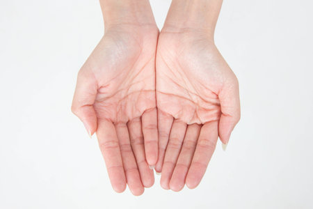 two empty female teen hands pleading, isolated on whiteの写真素材