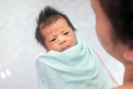 Newborn baby infant with mother home room portraitの写真素材