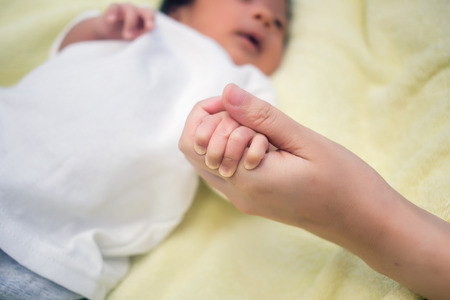 close up of a mother's and baby's hands holdingの写真素材