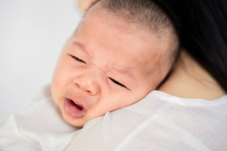 Mother trying to comfort her crying baby isolatedの写真素材