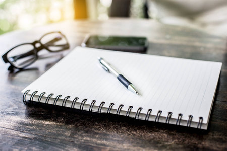 notebook and pen on a wooden tableの写真素材