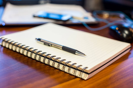 notebook and pen on a wooden tableの写真素材