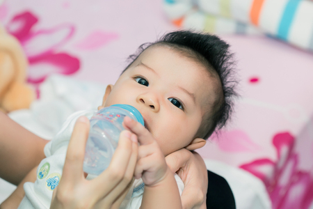 Cute baby in bed smiling and looking at camera.の写真素材