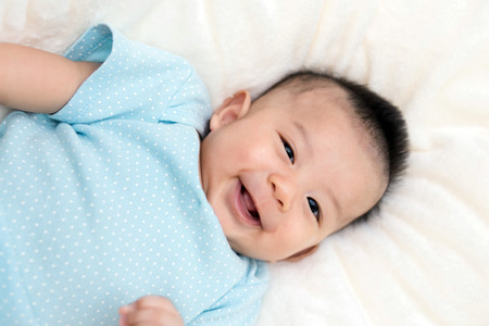 Portrait of a crawling baby on the bed in her room