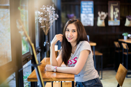 Portrait of a beautiful young asian woman relaxing at cafeの写真素材