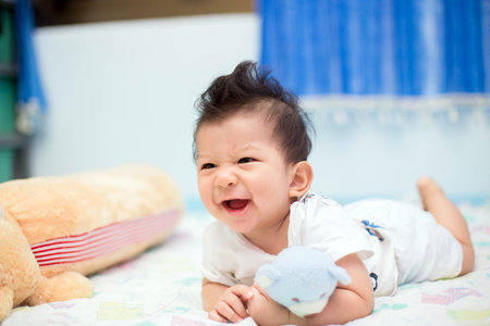Happy baby on a bed, lying and smiling.の写真素材