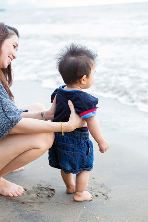 mother took the children to walk the white sand beach to walk.Blue sea A little waveの写真素材
