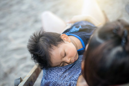 Baby and mom are relaxing on sunbedの写真素材