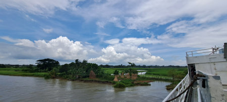 Landscape view of river and rice fields under blue sky with white cloudsの写真素材
