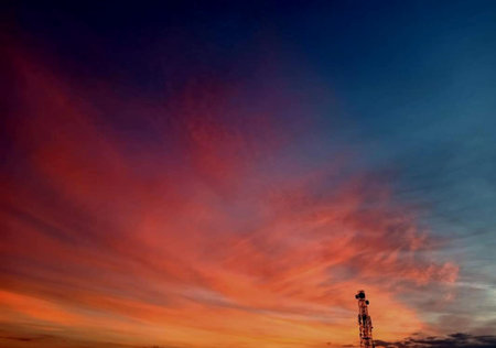 silhouette of telecommunication tower with red and blue sky backgroundの写真素材