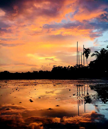 Reflection of the sky and clouds in the water at sunset.の写真素材