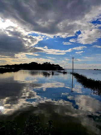 Reflection in the water of the sea and the sky with cloudsの写真素材