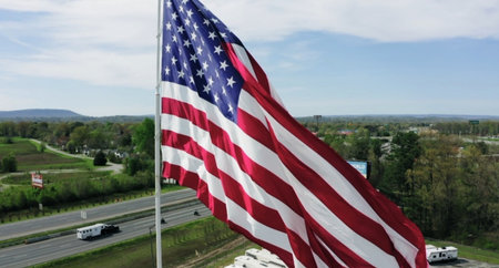 American flag waving in the wind on the background of the highway.の写真素材