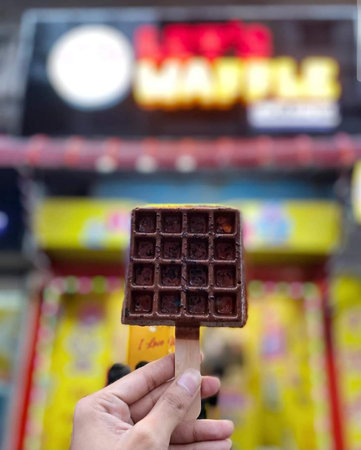 Chocolate wafers on a stick in hand with blurred backgroundの写真素材