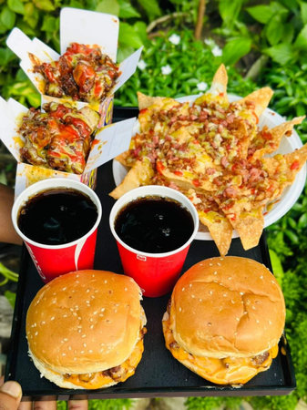 Hamburger and cola in paper cups on the table.の写真素材