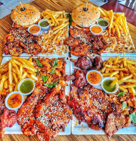 Grilled pork ribs with french fries and sauces on a wooden board
