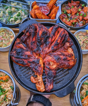 Barbecue grill with grilled chicken wings, vegetables and sausagesの写真素材
