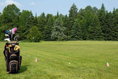 golf equipment on the green grass of golf course in summer dayの写真素材