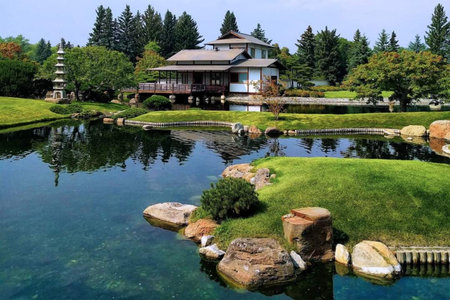 Japanese garden with a pond and a Japanese temple in the background.の写真素材