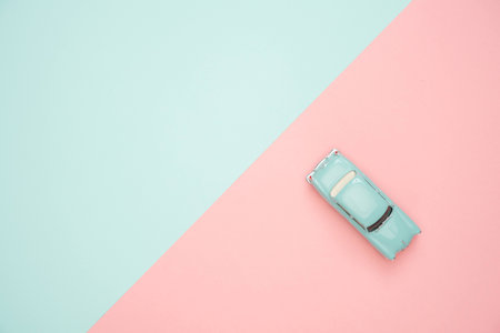 Toy car on pastel blue and pink background. Minimal style.の写真素材
