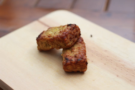 a close up of fried tempeh on a wooden cutting board. Indonesian traditional food concept.の写真素材