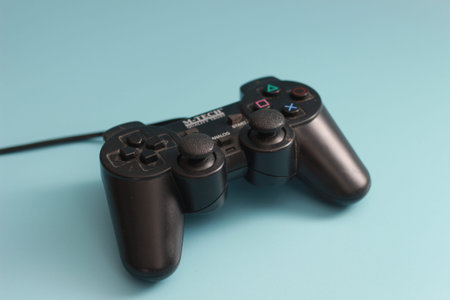 a close up of a joystick in black isolated on a blue background. online game tool photo concept.