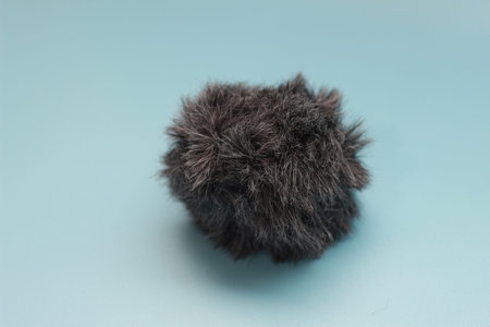 a close up of a cat fur shaped microphone silencer. audio visual work equipment concept.