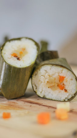 a close up of Lontong. Traditional food from Indonesia originating from rice filled with vegetables or meat and wrapped in banana leaves. Indonesian traditional food photo concept.の写真素材