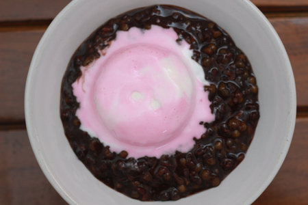 close up of a bowl of black sticky rice porridge topped with strawberry ice cream. Food concept photo.の写真素材