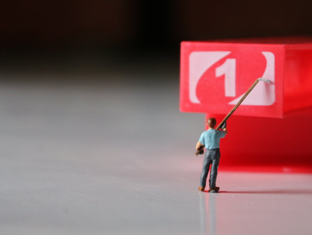 a close up of miniature figures of workers coloring objects by numbers. Coloring photo concept.の写真素材
