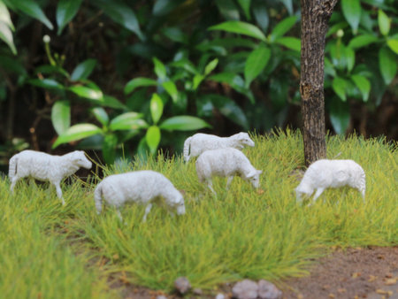 a close up of miniature figures of a herd of goats eating grass. Animal farm photo concept.の写真素材