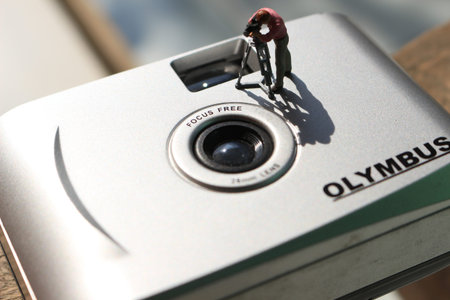 miniature figure of a videographer recording on an analog camera.