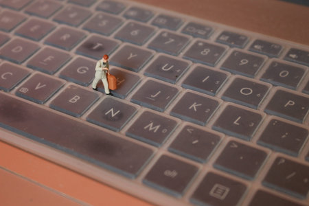 a miniature figure of an office worker carrying a briefcase walking between the keyboards.の写真素材