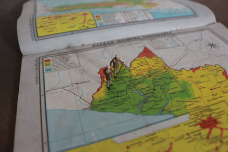 miniature figure of an explorer posing on a map or atlas